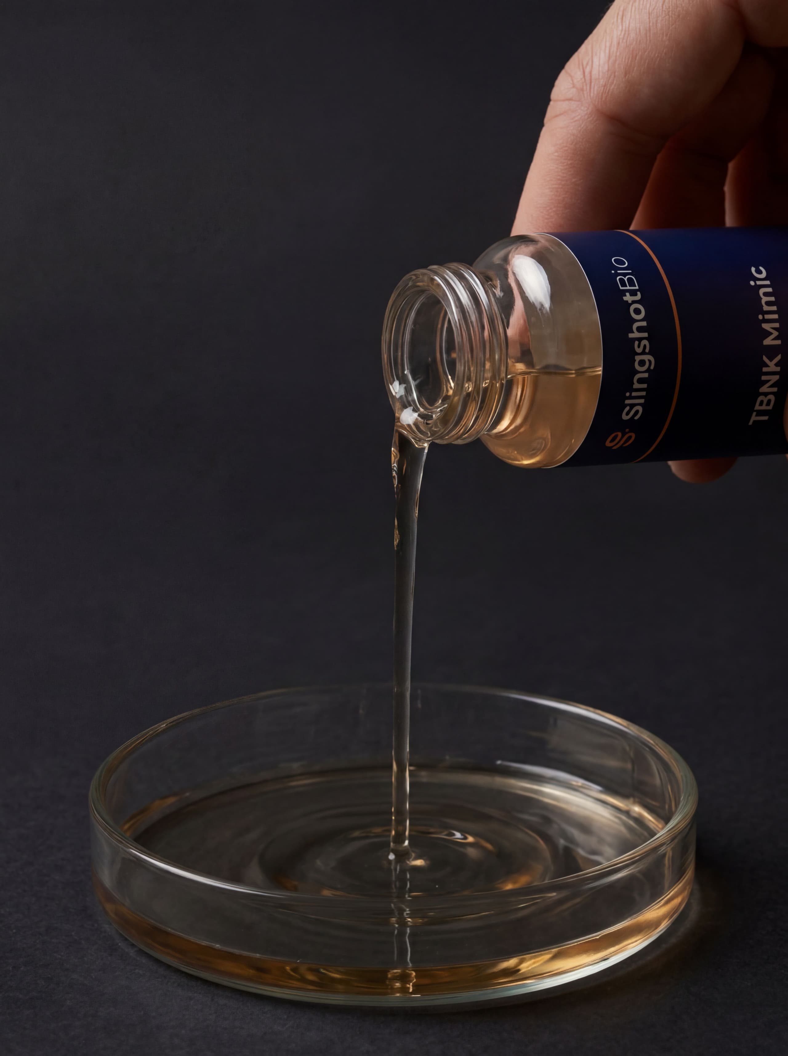 Hand pouring product into a petri dish